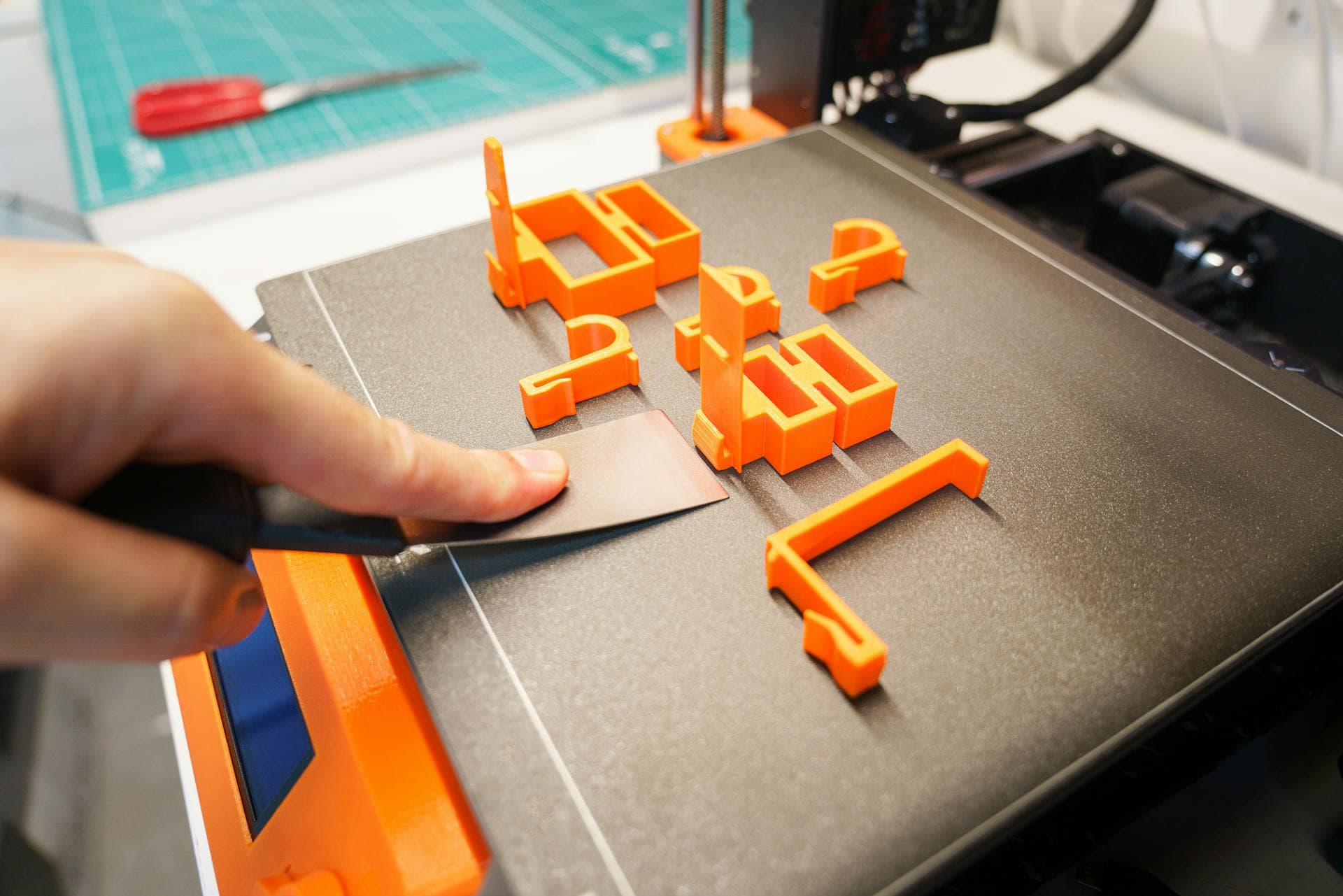 Voxelyo maker hand-finishing a 3D-printed designer toy figure in Premium PLA